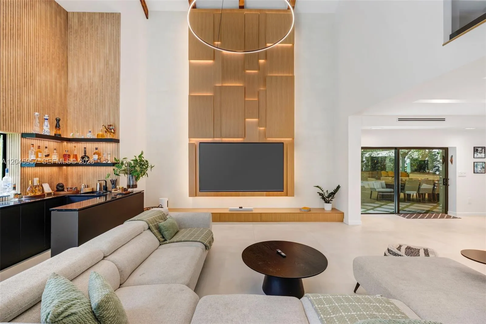 The heart of the home, with soaring two-story ceilings, dramatic architectural volume, and a custom feature wall creates an unforgettable first impression