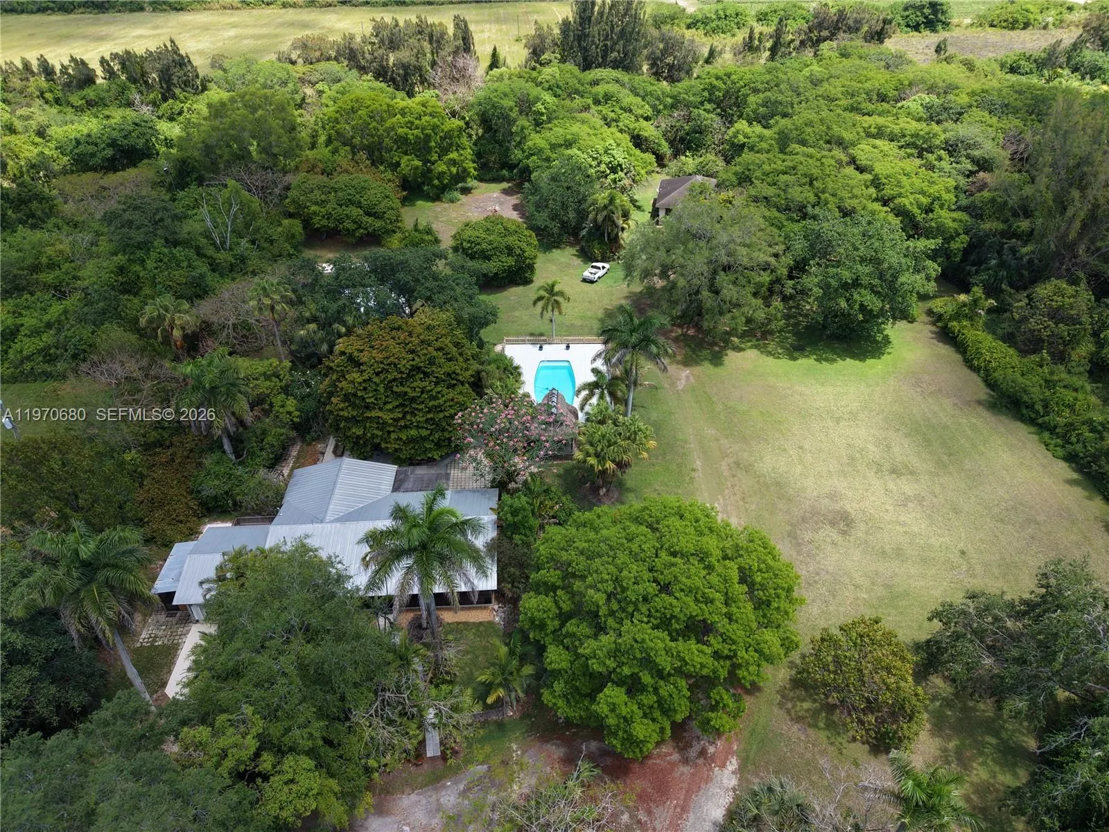AERIAL VIEW FIVE ACRE COMPOUND OF TWO HOMES, POOL, DETACHED GARAGE, POLE BARN, RV PAD WITH UTILITIES.