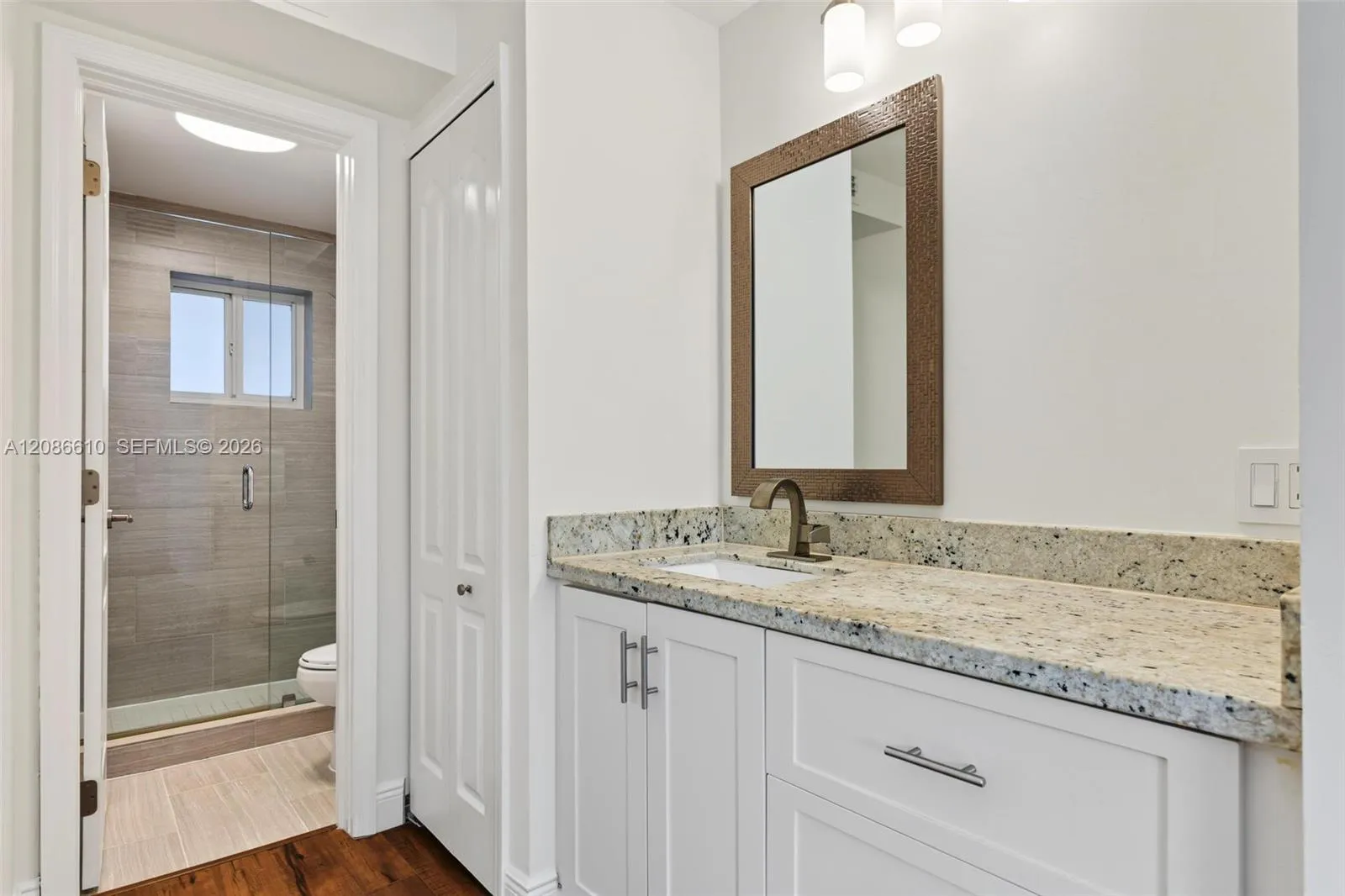 Granite counters, crisp white cabinetry and thoughtful storage create a polished space for your morning and evening routines.