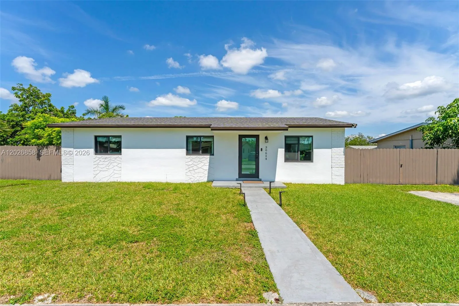 Modern curb appeal with fresh exterior paint, updated windows, and a spacious front yard.