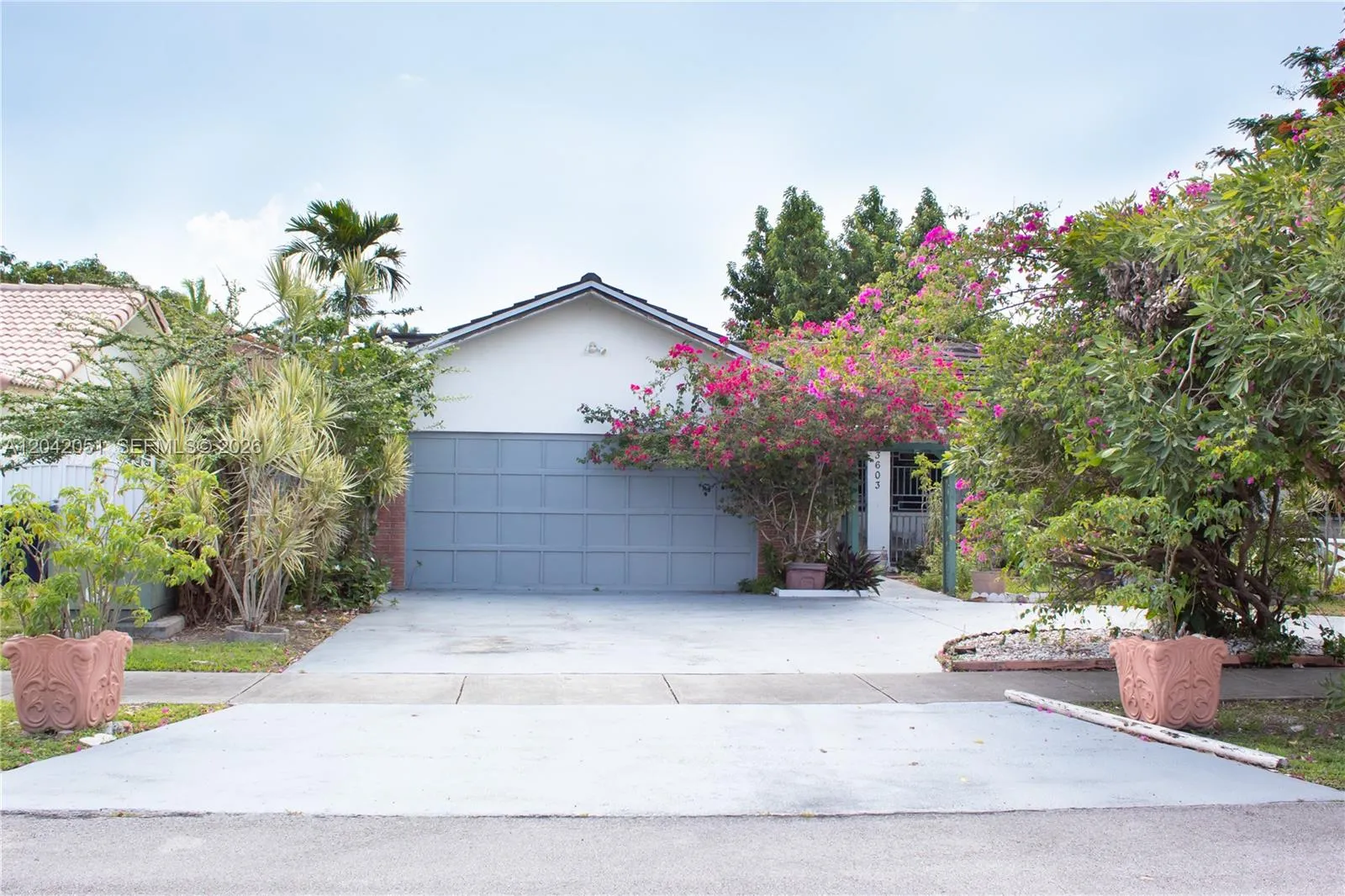Wide driveay plus a circular driveway allows for multiple cars to comfortably park at the home. There is a side entrance to the backyard on the left with a gate and a walk-way that leads to the dedicated separate entrance into the Studio/Home Office. The main entrance of the home is on the right.