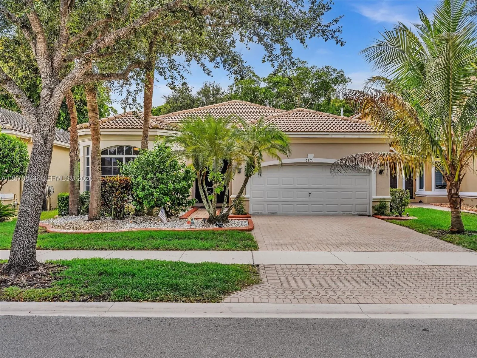 Inviting curb appeal with a beautifully maintained front landscape and a spacious driveway offering additional parking.