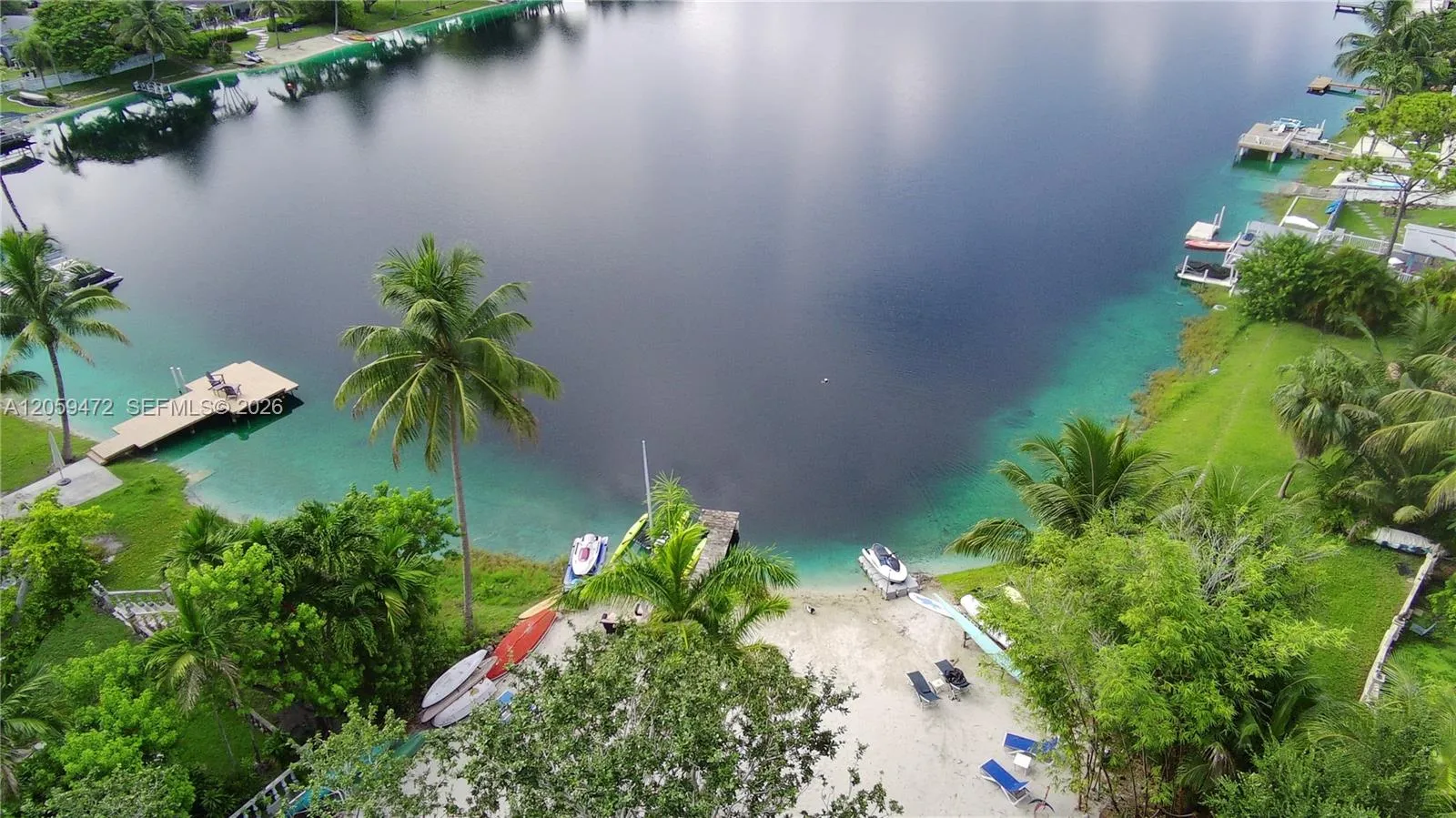 Breathtaking aerial perspective showcasing the expansive waterfront lot, private dock, and lush tropical surroundings — true Florida paradise.