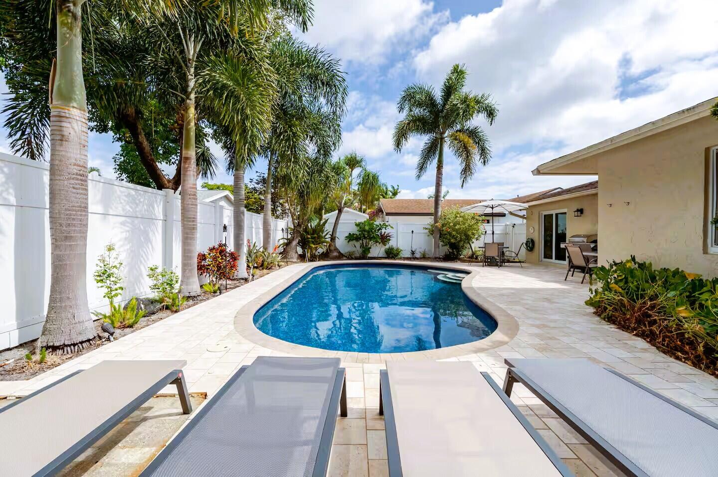 Freeform swimming pool surrounded by a paver patio