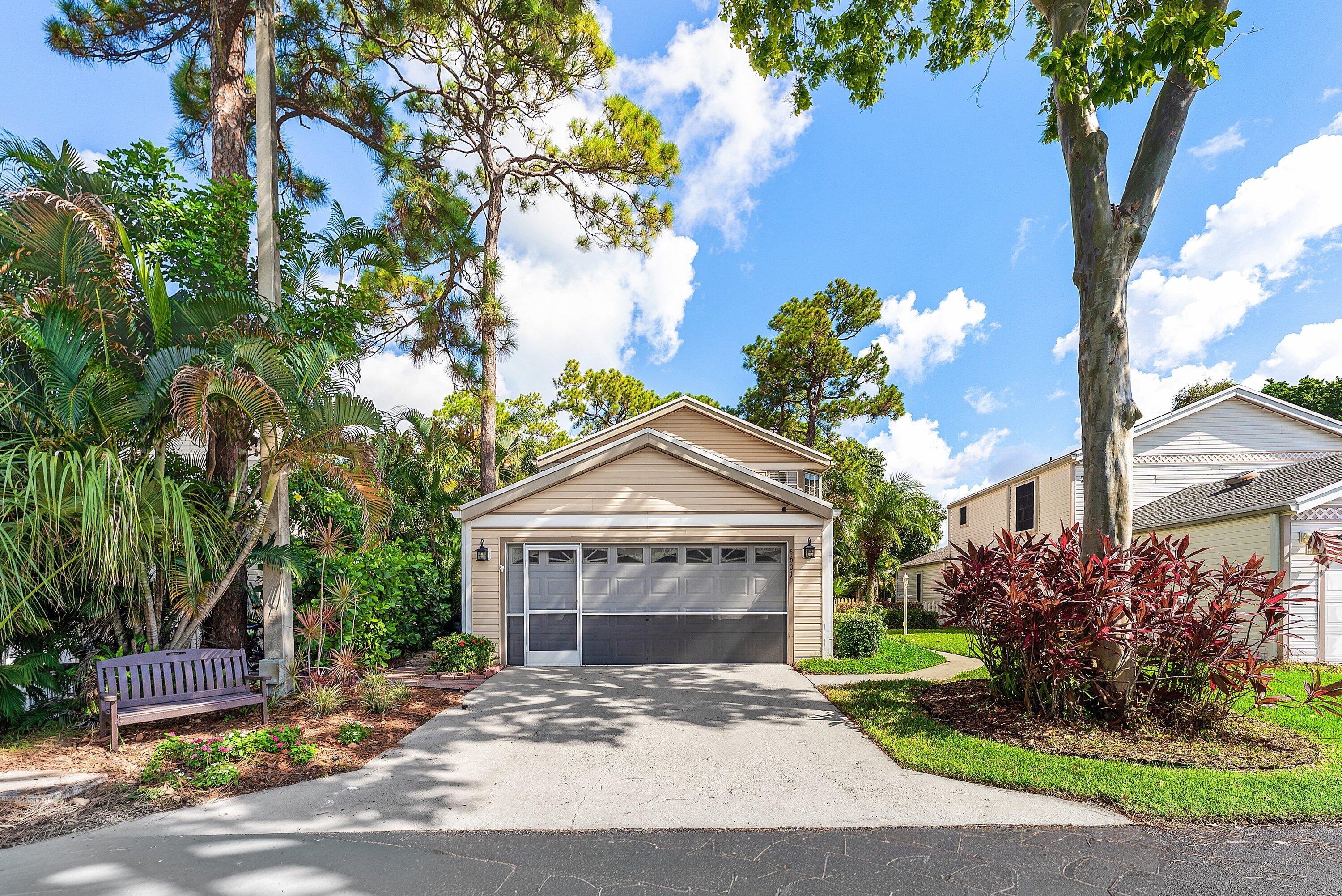 Siding exterior with an attached garage featuring a screen enclosure and concrete driveway