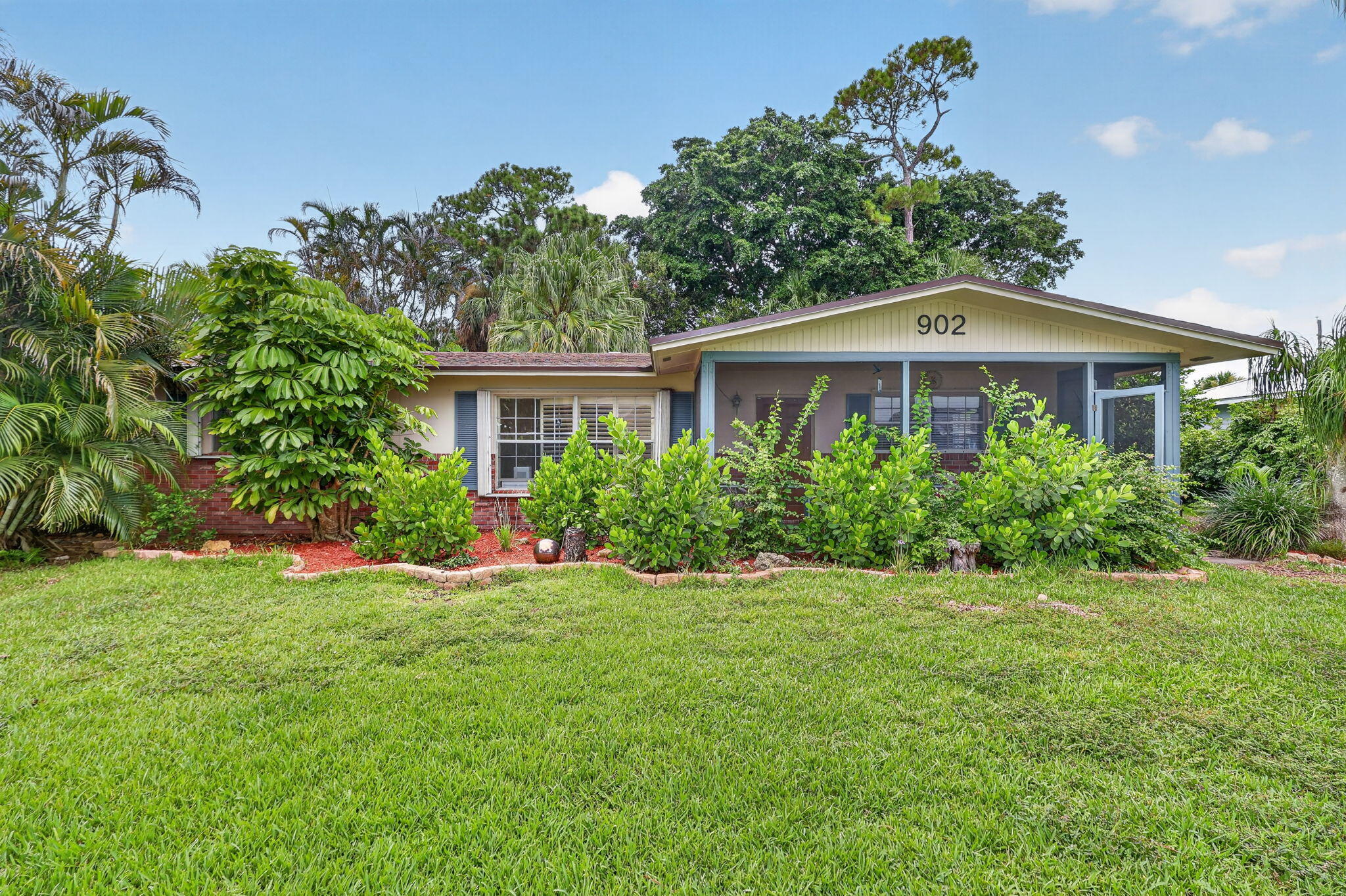 Ranch-style exterior with brick detailing, light-toned siding, and a screened front porch