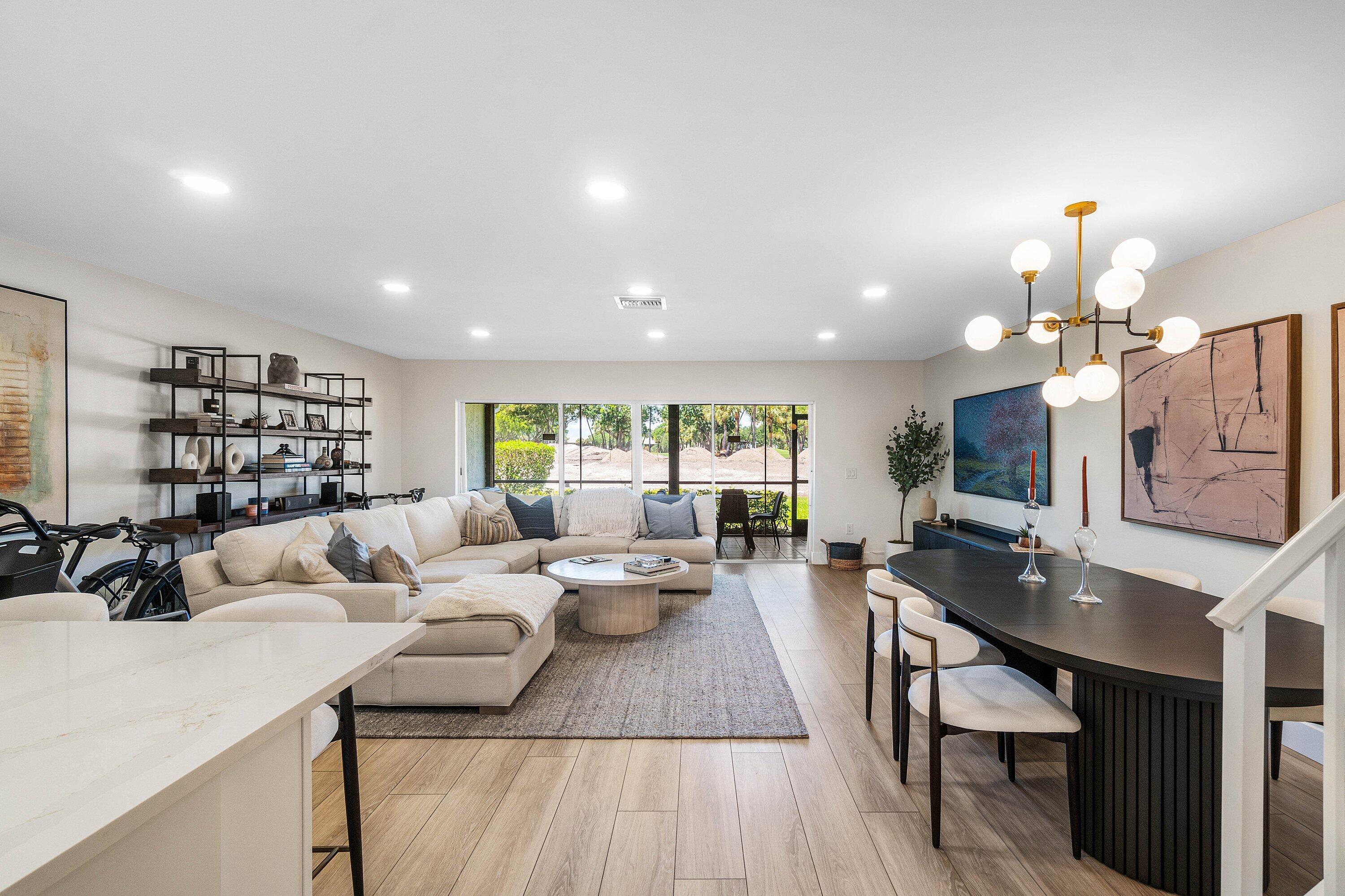 Recessed lighting, wood-finish flooring, and a modern dining chandelier