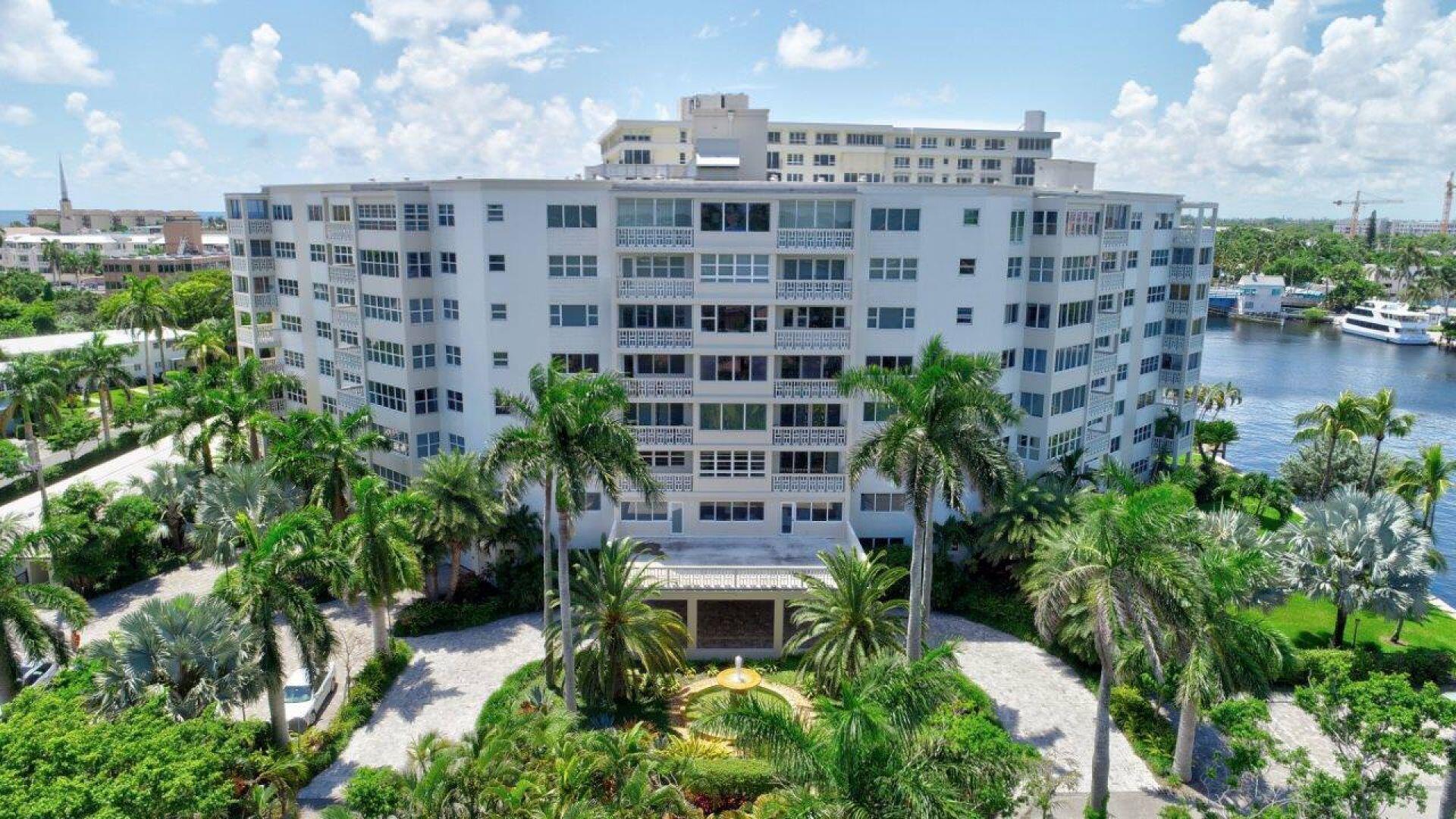 Multi-story residential building with private balconies and tropical landscaping