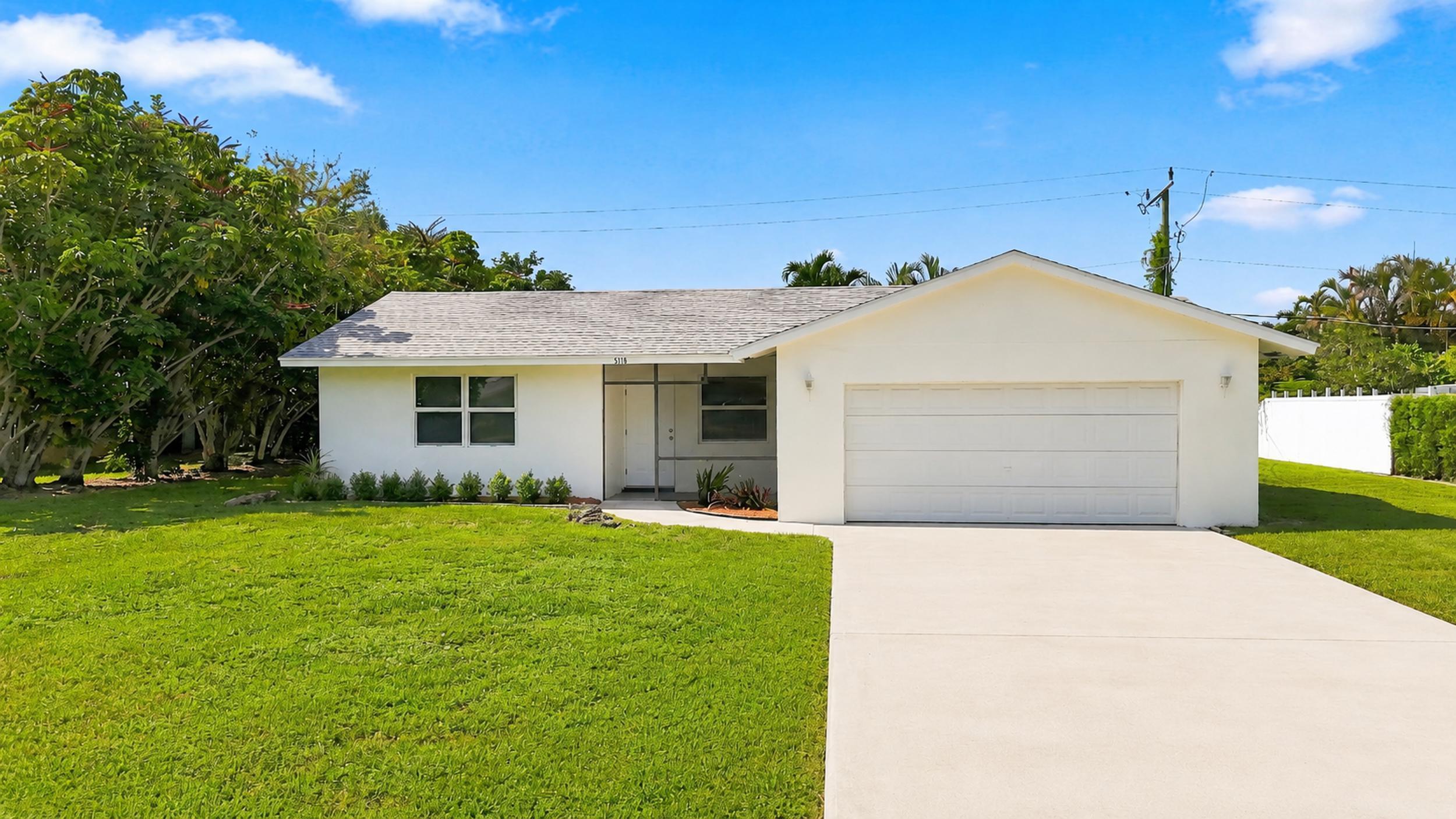 Front view of the home with attached garage, driveway, and lawn.