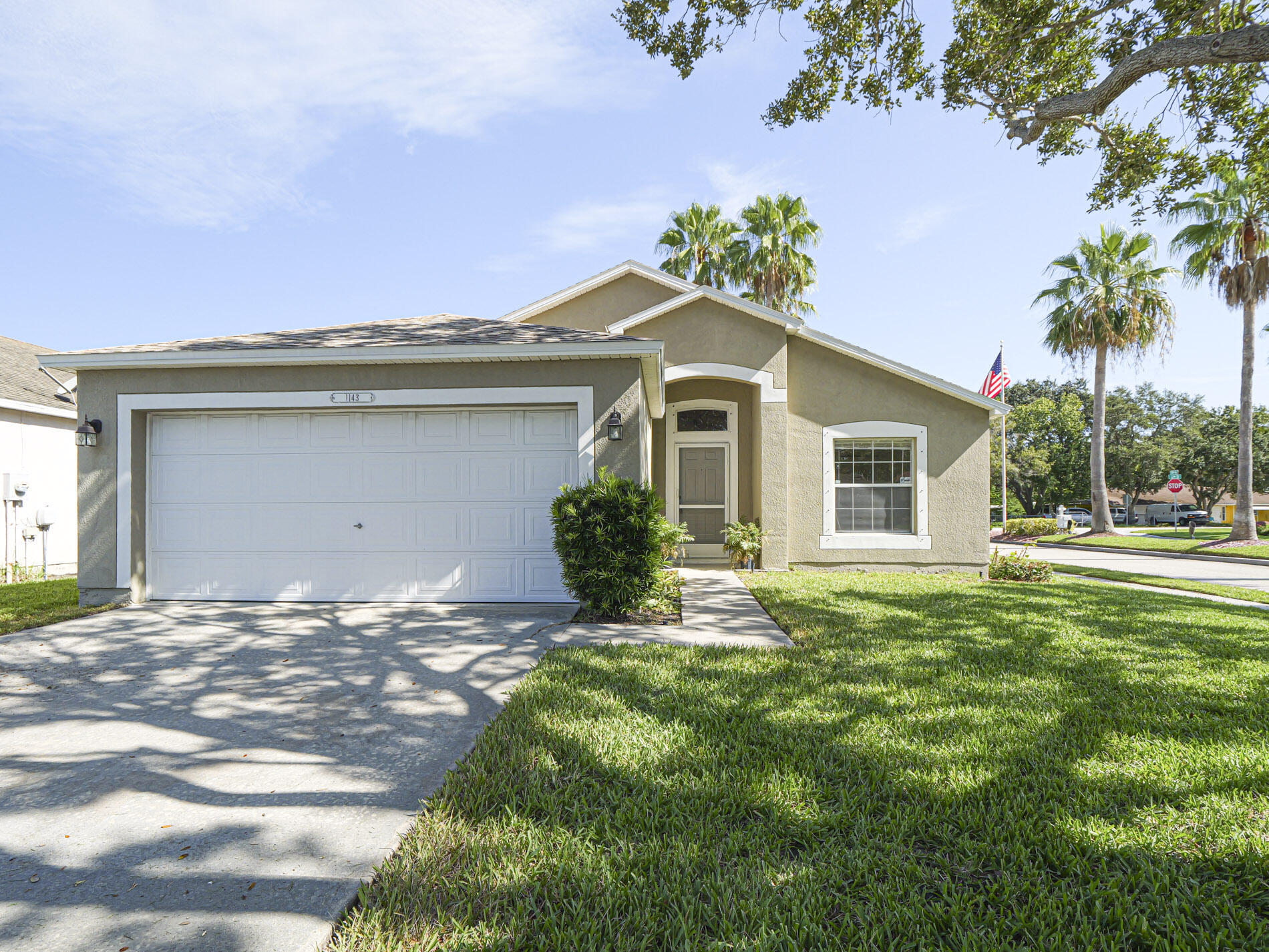 Single-story residence featuring stucco exterior, an attached garage, and a concrete driveway