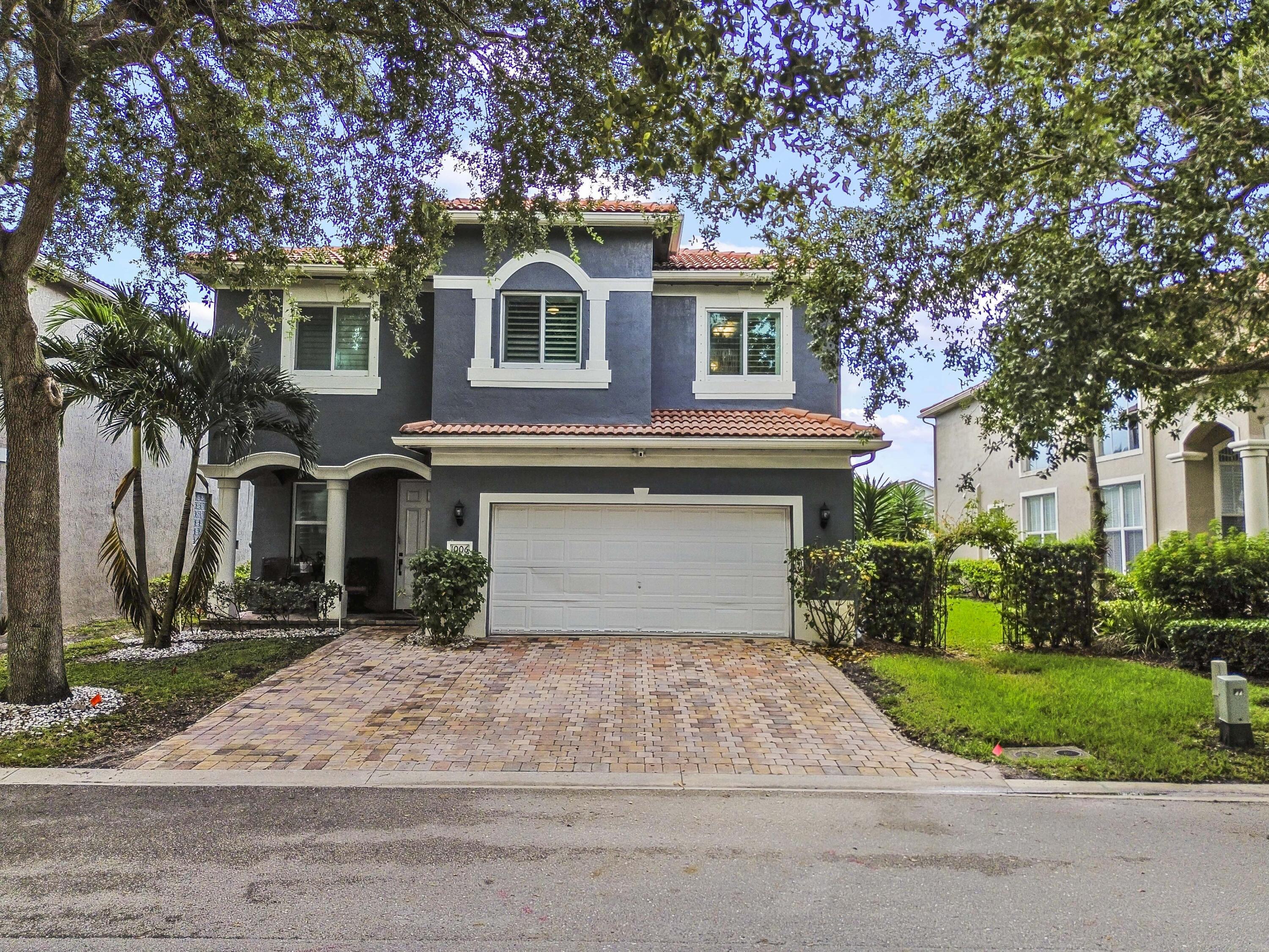 Two-story residence with a red tile roof, arched entryway, and an integrated garage