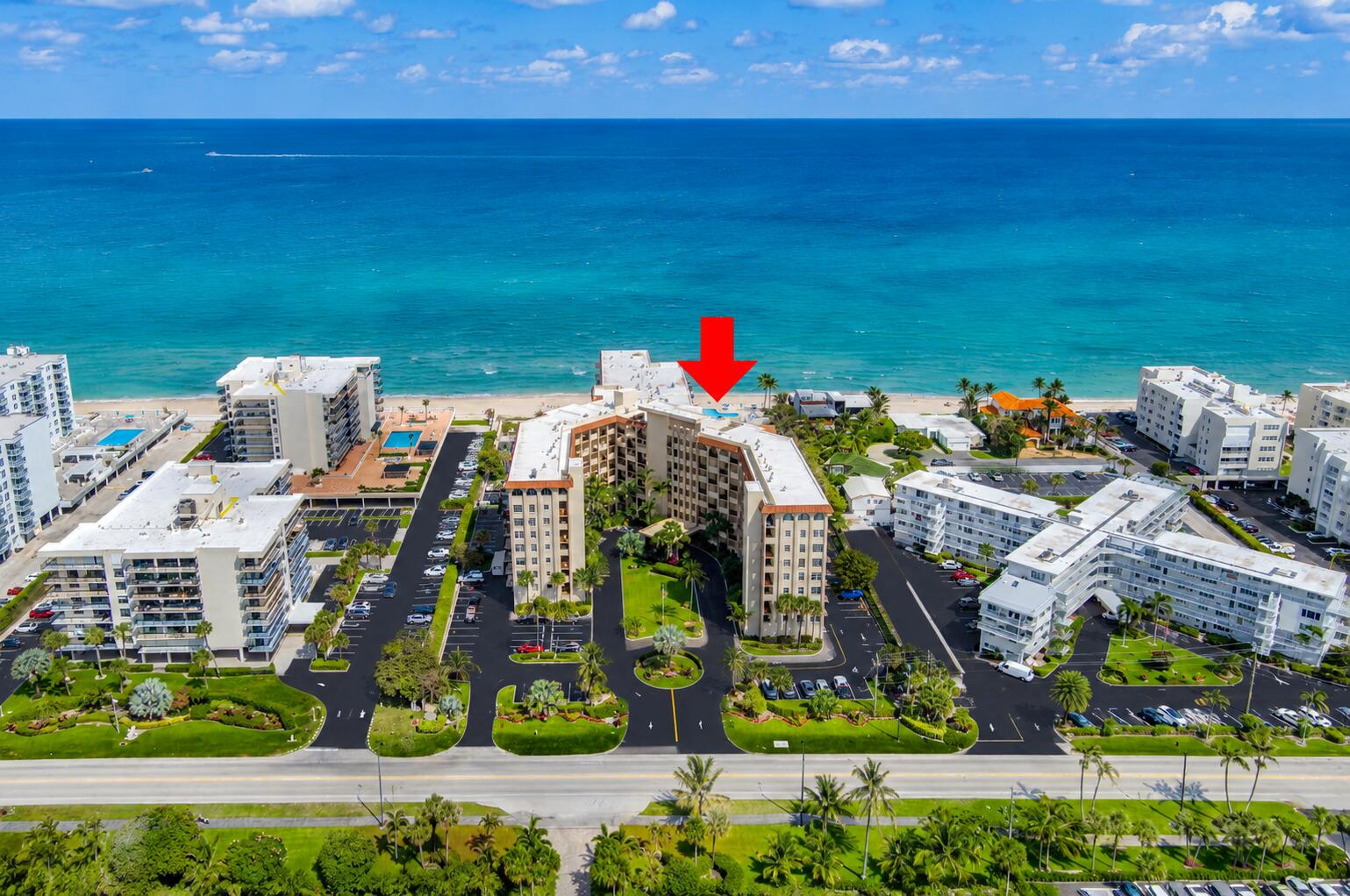 Beachfront multi-story building featuring a U-shaped design, a central green space, and direct beach access