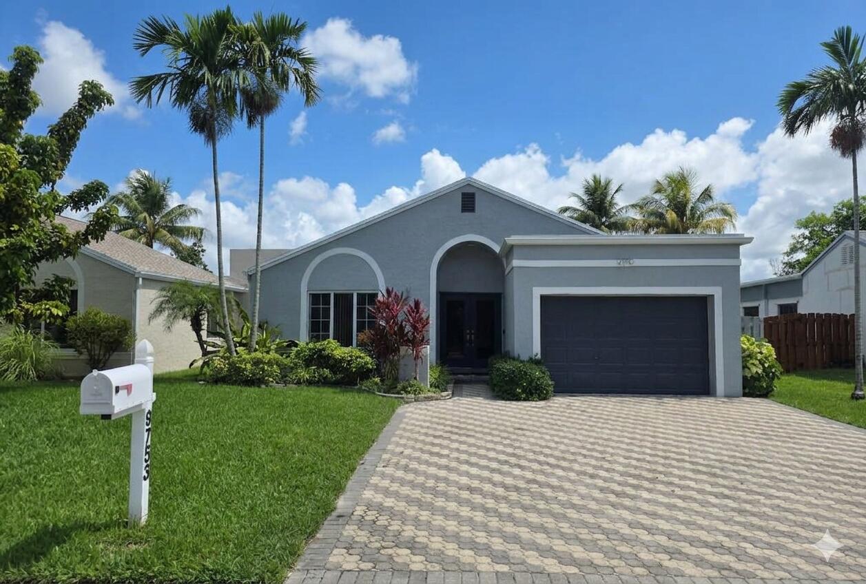 Contemporary residence with a paver driveway, an attached garage, and a manicured lawn