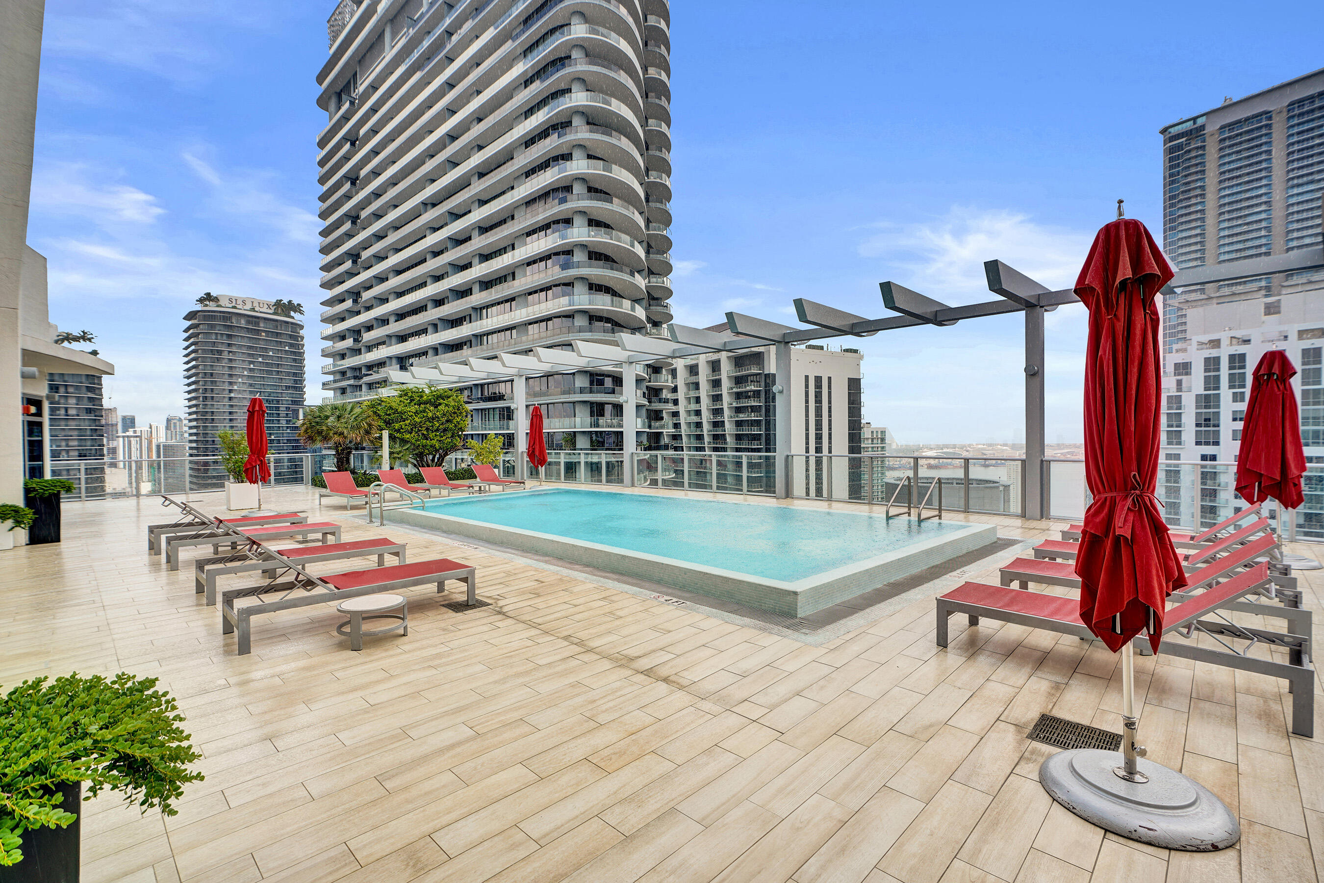 Rooftop terrace with a rectangular pool, surrounded by paver flooring