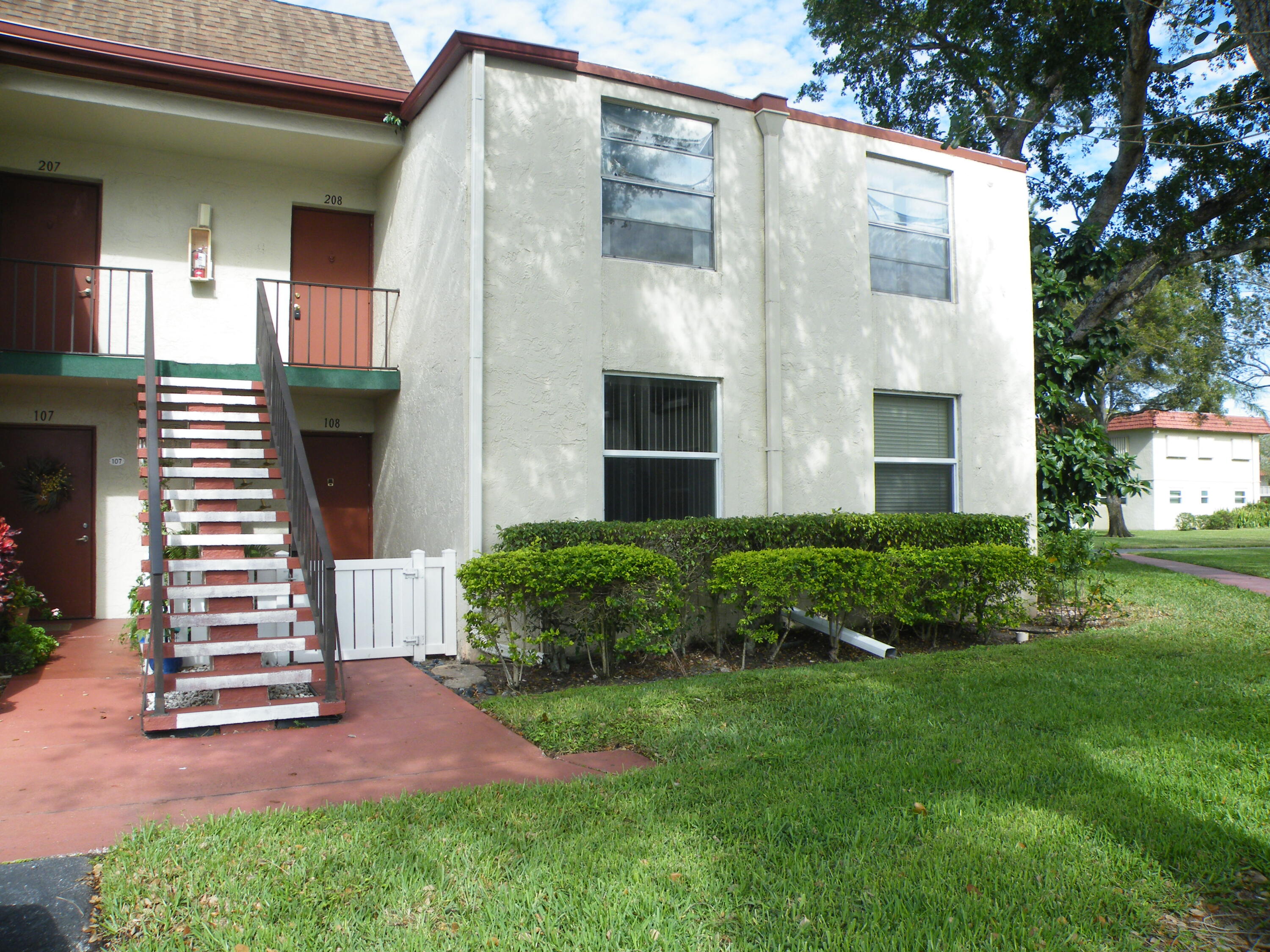 Two-story stucco exterior with brown trim and a shingle roof