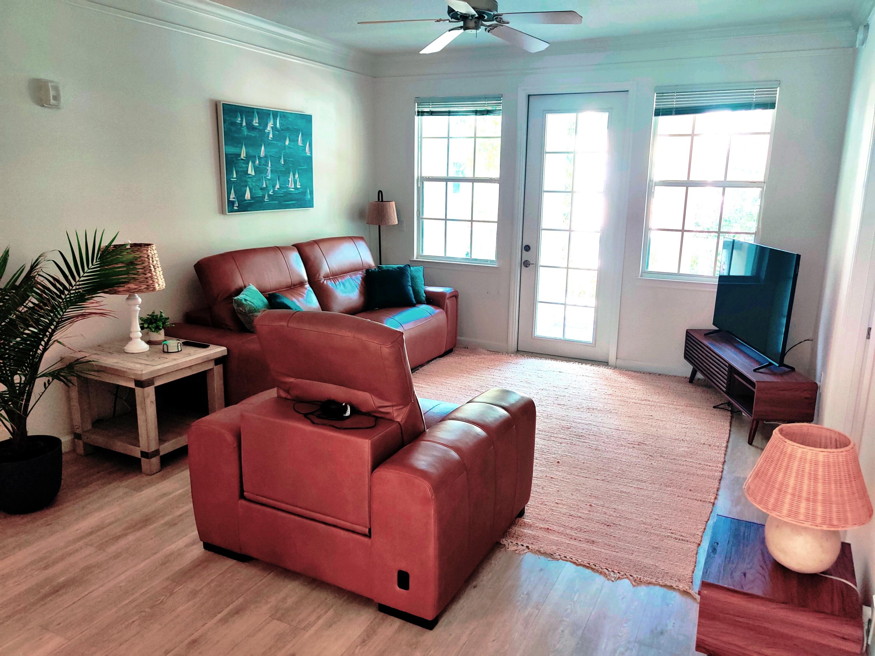 Living room with door opening onto balcony over looking Abacoa.