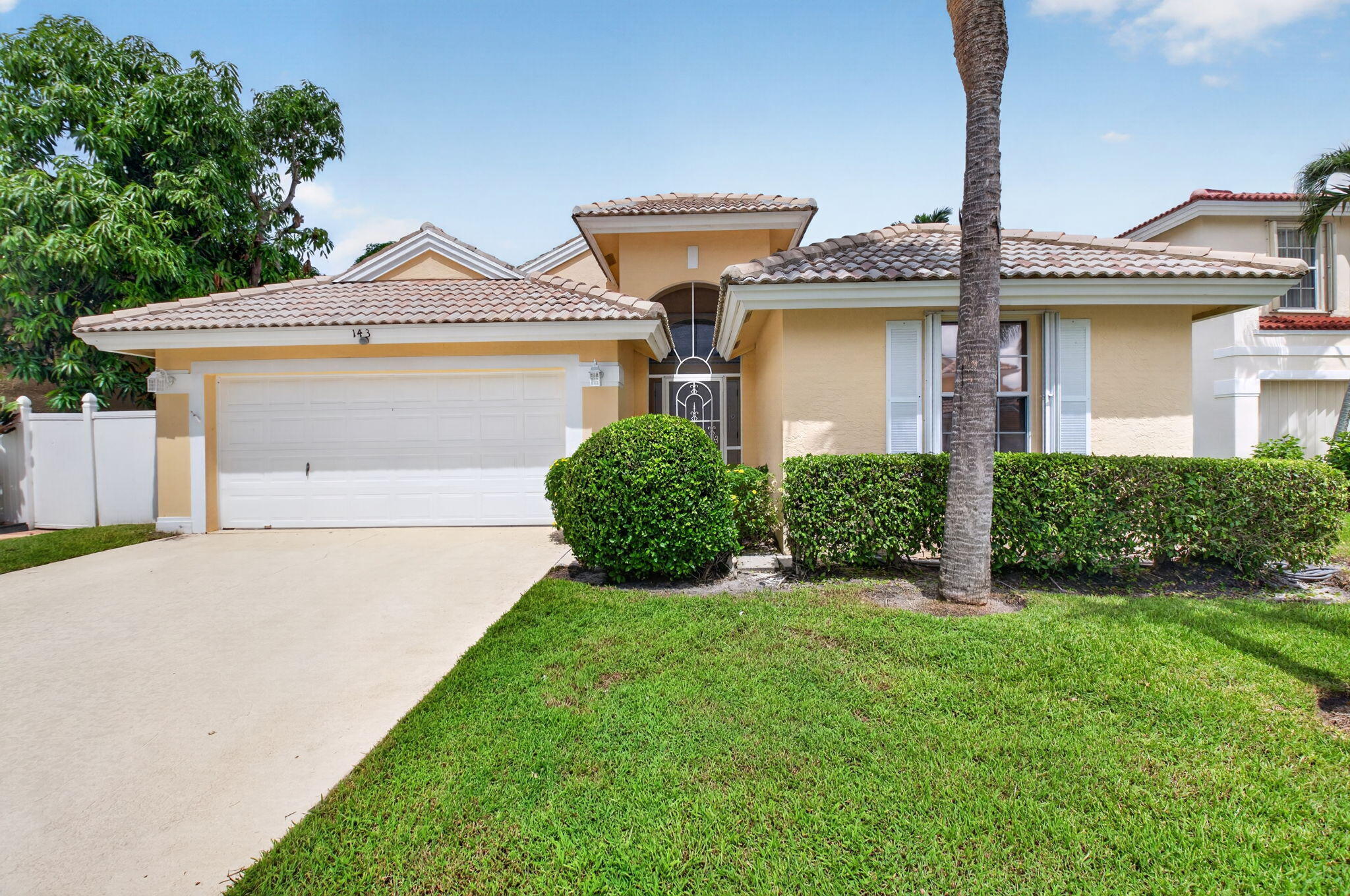 Single-story residence featuring a tile roof, stucco exterior, and an attached two-car garage