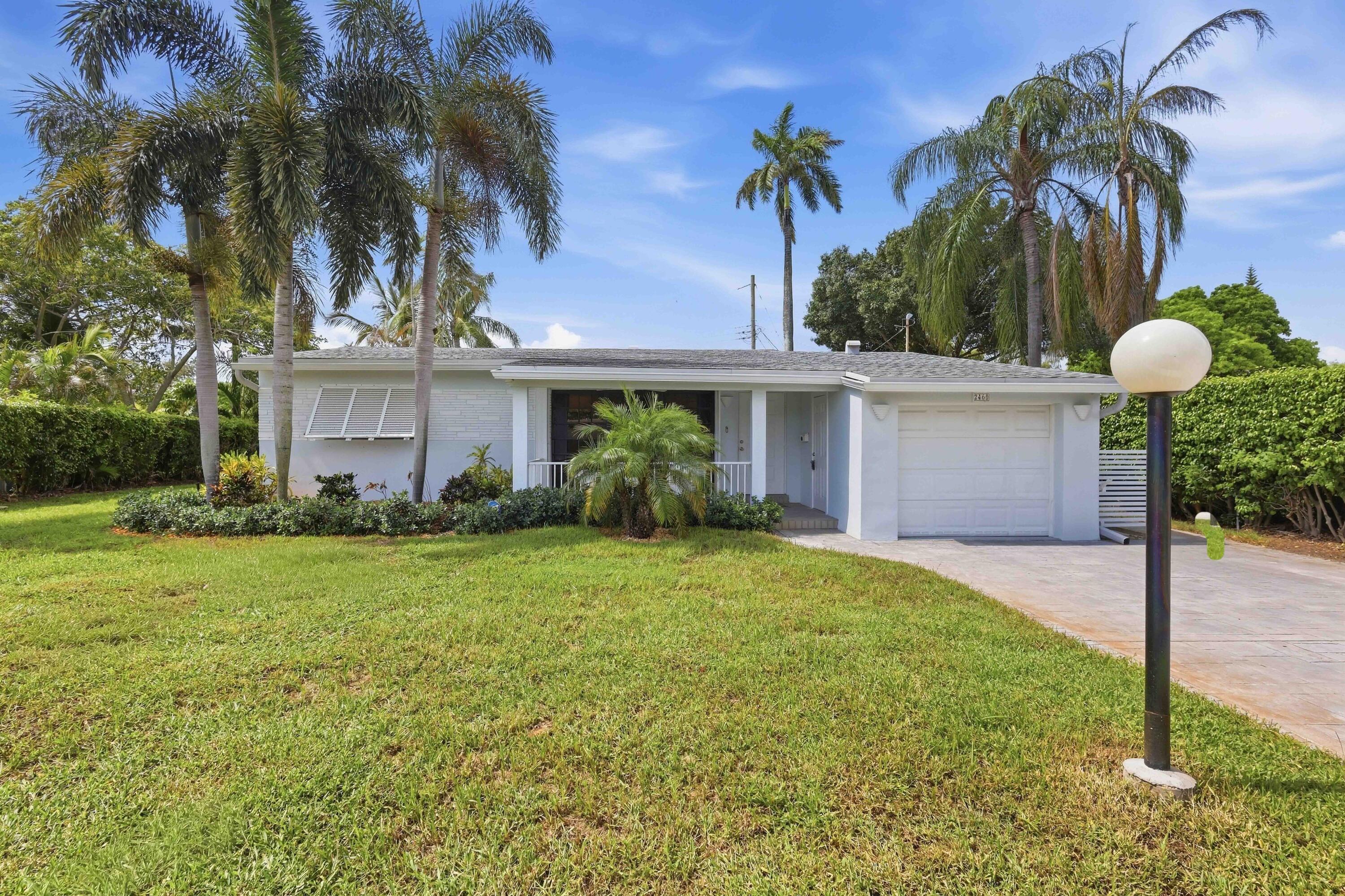 Lovely Single-story residence featuring a beautiful porch, white exterior, attached garage, and a concrete driveway