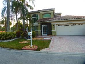 Stucco exterior with a tile roof, arched entryway, and an integrated two-car garage