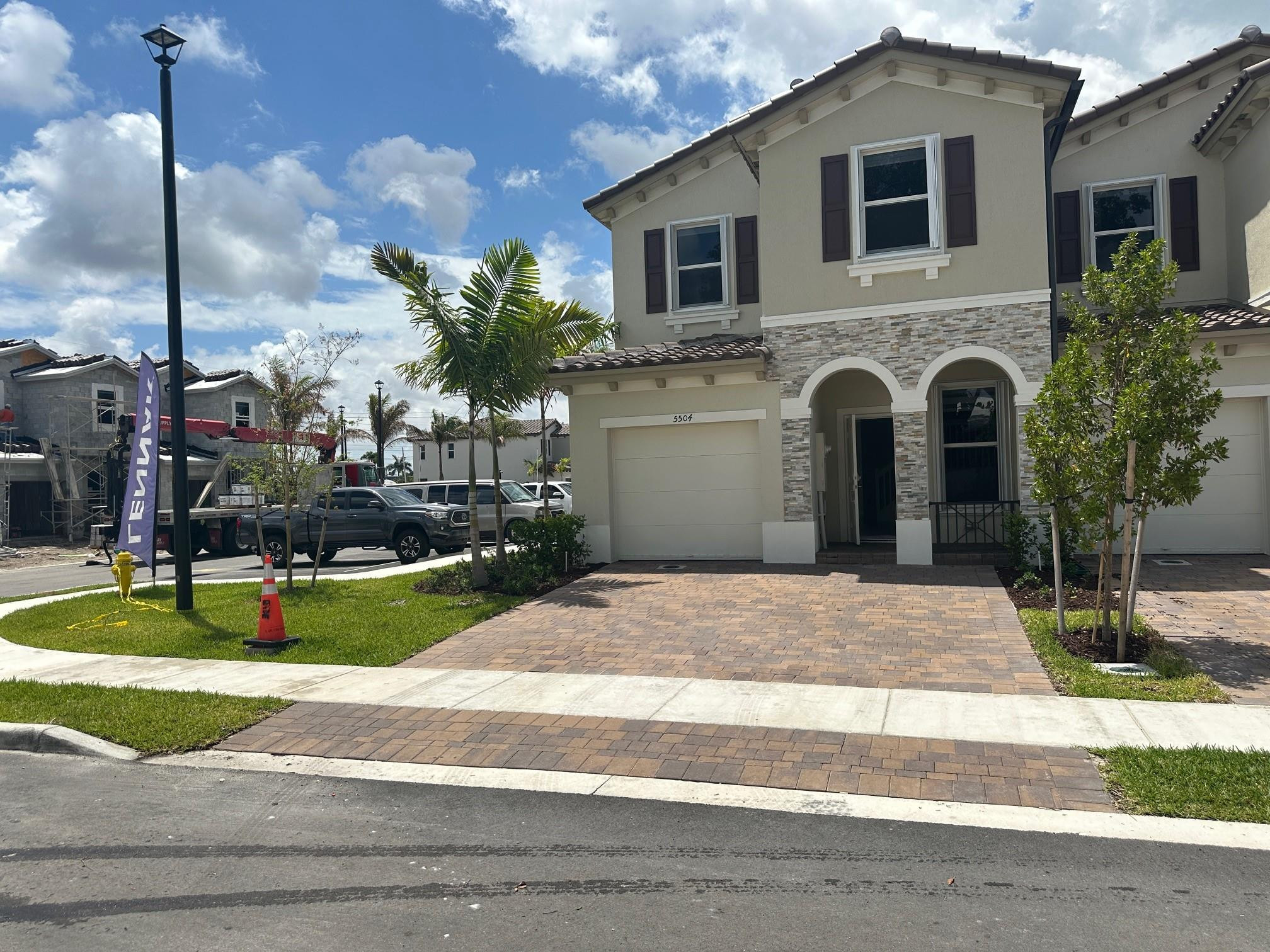 Two-story facade with stone veneer accents, arched entryway, and decorative window shutters
