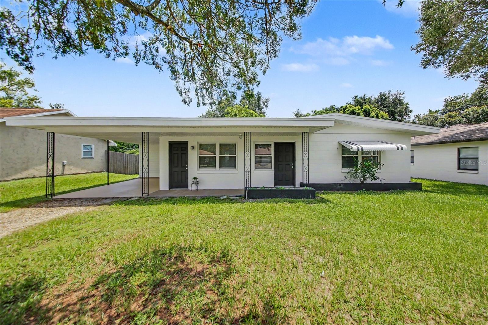 Updated Winter Park home with fresh curb appeal, a new roof, dual-pane energy-efficient windows, attached carport, welcoming front walkway, and no HOA.