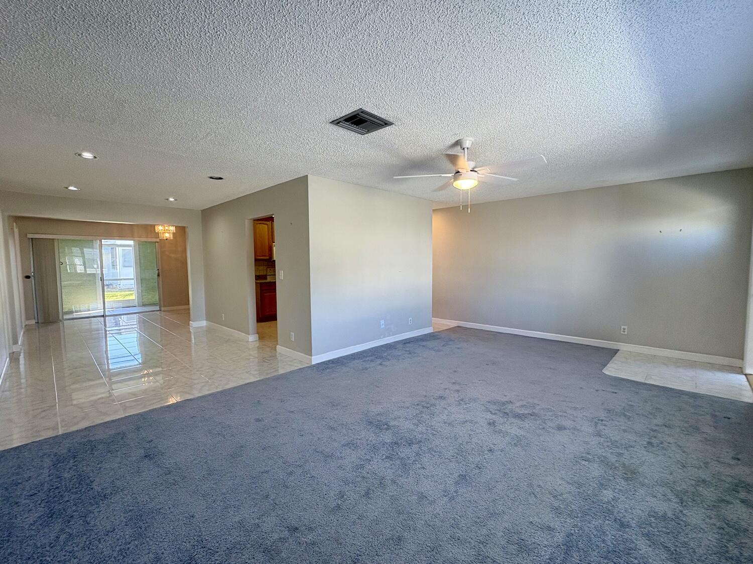 Living room leads to open area with kitchen in the center
